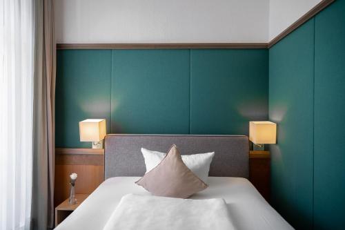 a bedroom with a bed with a green wall at Manufaktur Boutique Hotel in Stadt Wehlen