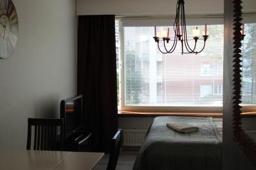 - une chambre avec un lit et une fenêtre ornée d'un lustre dans l'établissement Studio Kaarto, à Rovaniemi