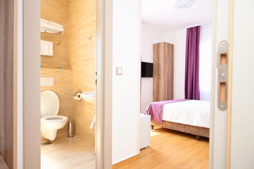 bagno con letto e servizi igienici in camera. di Dona, Altina a Belgrado