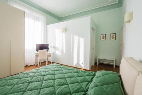 a bedroom with a green bed and a desk at Hortensia Garden in Macerata