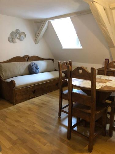 a room with a couch and a table and a window at Les appartements du Koifhus in Colmar