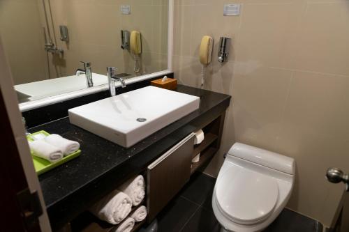 a bathroom with a sink and a toilet and a phone at Prime Plaza Suites Sanur – Bali in Sanur