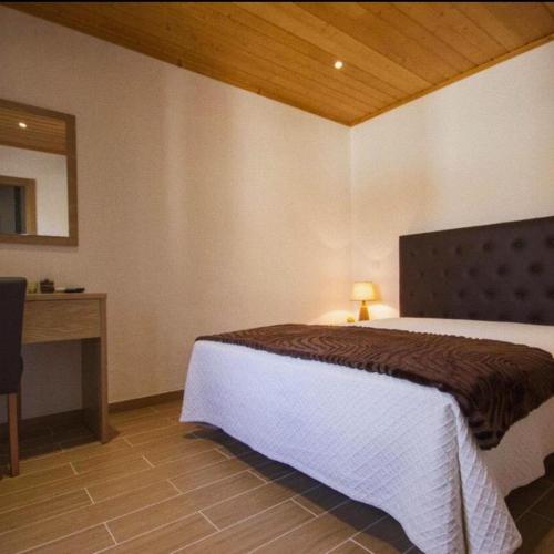 a bedroom with a bed and a desk and a bed sidx sidx sidx at Casa De Campo Cantinho Da Serra in Cortelha