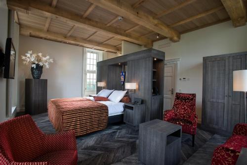 a bedroom with a large bed and two chairs at Romantik Hotel Kasteel Daelenbroeck in Herkenbosch