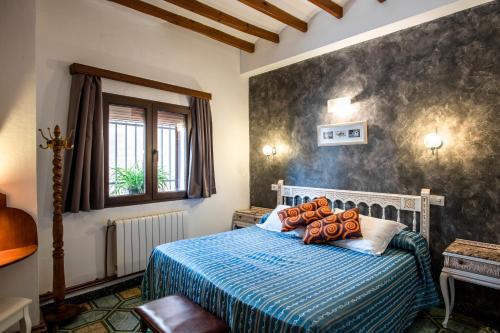 a bedroom with a bed with a blue comforter at Hotel Casa Pilar Adults Only in Castell de Castells