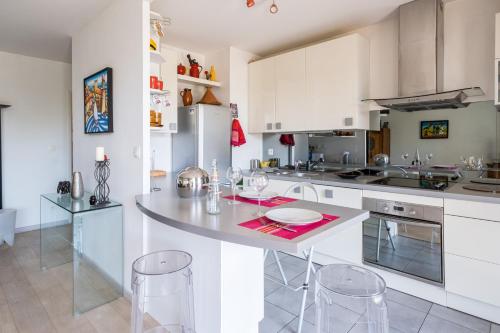 une cuisine avec des armoires blanches et une table avec des chaises dans l'établissement Les Amidonniers, à Toulouse