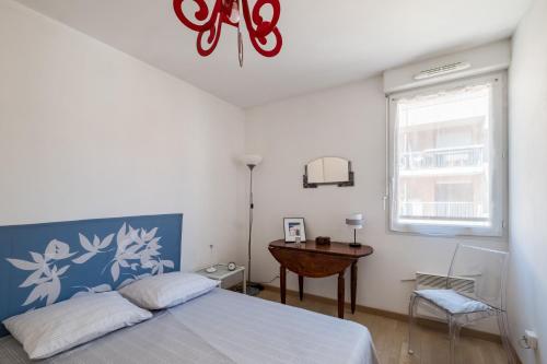 une chambre avec un lit, une table et une fenêtre dans l'établissement Les Amidonniers, à Toulouse