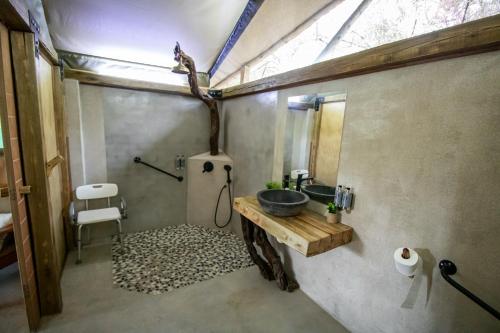 ein Bad mit einem Waschbecken und einem Spiegel in der Unterkunft Little Africa Safari Lodge in Hoedspruit