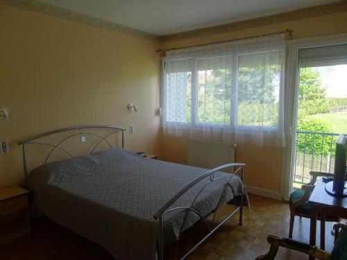 a bedroom with a bed and a window at Le Panoramic in Bains-les-Bains