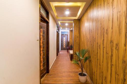 a hallway with wooden walls and a potted plant at FabHotel GMC Grand in Lucknow