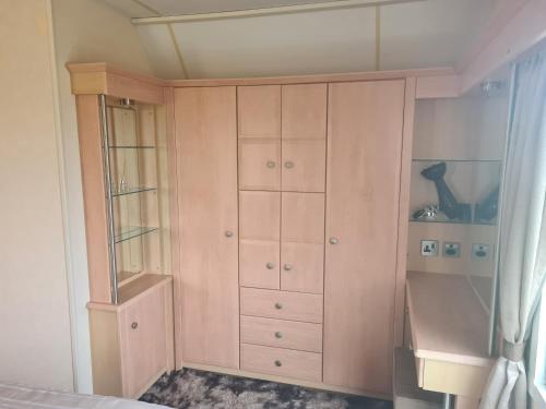 a bedroom with a cupboard and a bed at 6 Berth The Chase Ingoldmells Concept in Ingoldmells