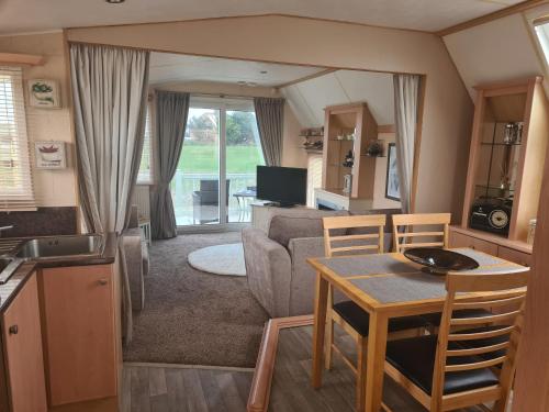 a living room with a table and a couch at 6 Berth The Chase Ingoldmells Concept in Ingoldmells