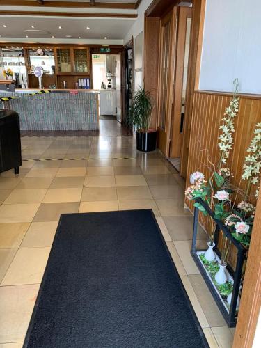 a lobby with a hallway with plants on the floor at Hotel Zur Aue in Wesel