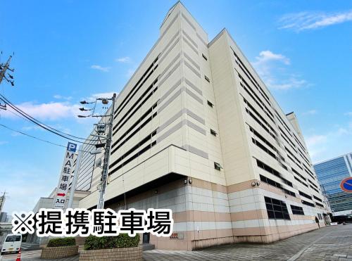 a large white building with writing on it at Hotel Trend Mikawaanjo in Anjomachi