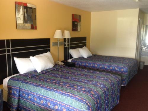 Countryside Inn في Wharton: غرفه فندقيه سريرين ومصباحين