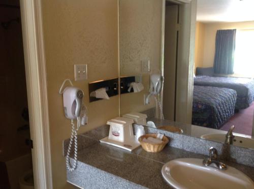 霍頓的住宿－Countryside Inn，一间酒店客房内的带水槽和电话的浴室