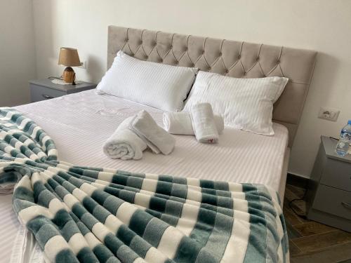 Daily Apartment Tirana في تيرانا: غرفة نوم عليها سرير وفوط