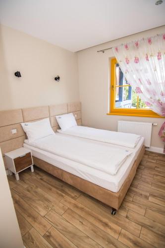a bedroom with a large bed with a window at Szklarska Poręba Apartament 601 Słoneczny in Szklarska Poręba