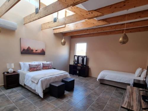 a bedroom with two beds and wooden ceilings at Avonlea Guesthouse in Polokwane