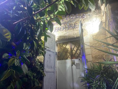een open deur in een stenen gebouw met planten bij Guest House Antique in Nazareth