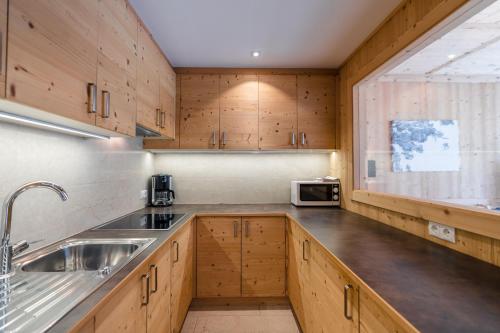 eine Küche mit Holzschränken und einem Waschbecken in der Unterkunft Ciasa Agreiter in Stern