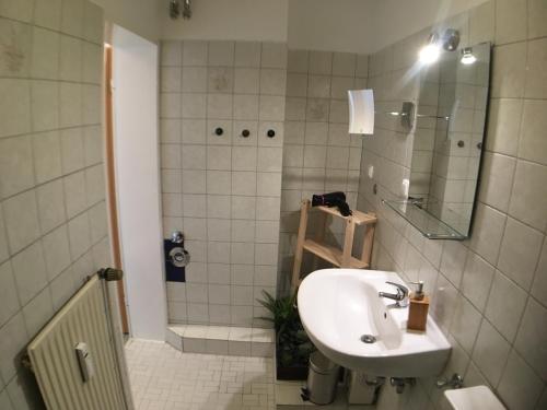 a bathroom with a sink and a shower with a mirror at Business-Apartment Rathausstraße - 34qm Privatssphäre in Bargteheide