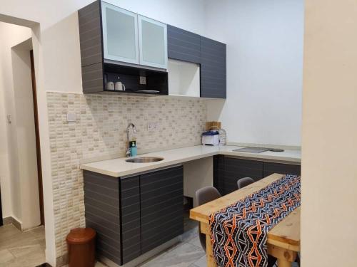 a small kitchen with a sink and a table at Tanzanite Apartment（Tanzanite Park） in Dar es Salaam