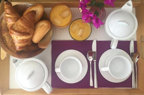 un tavolo con piatti bianchi e una ciotola di pane di Hotel Cyrnos a Cargèse