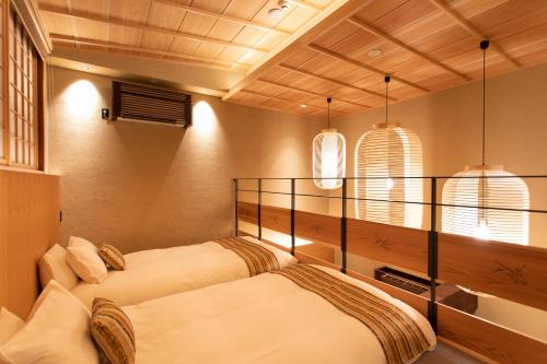 two beds in a room with two windows at Hotel Kanazawa Zoushi in Kanazawa