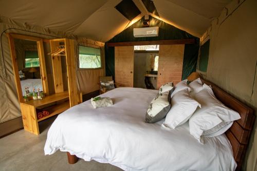 a bedroom with a large bed in a tent at Little Africa Safari Lodge in Hoedspruit