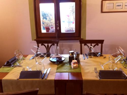 a table with two tables with wine glasses on it at Locanda Vesuna Hotel Countryhouse in Pienza