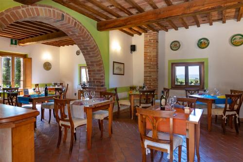 a restaurant with tables and chairs in a room at Locanda Vesuna Hotel Countryhouse in Pienza