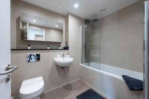 ein Bad mit einem WC, einem Waschbecken und einer Dusche in der Unterkunft A beautiful brand new flat 25-minute to London in Luton