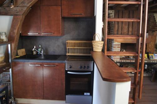 a kitchen with a stove and a counter top at Le perchoir de St-Antoine in Honfleur