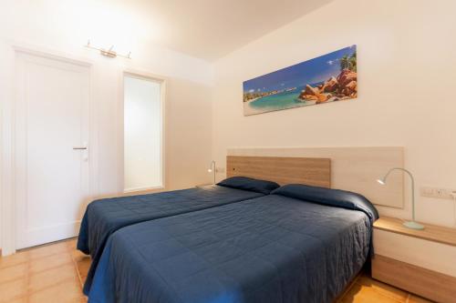 a bedroom with a bed with a blue bedspread at Princesa Ico in Puerto del Carmen