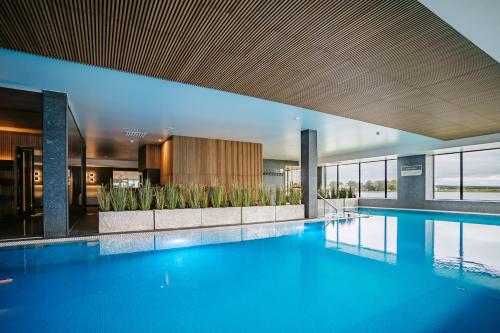 a large swimming pool with blue water in a building at Hestia Hotel Haapsalu SPA in Haapsalu