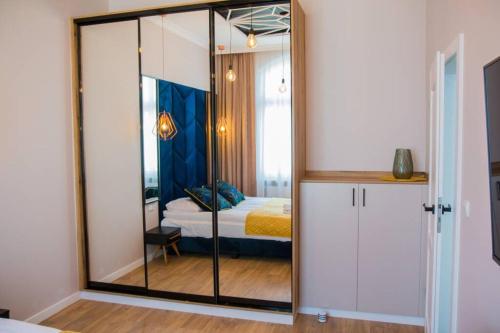 Pokój z lustrem i sypialnią z łóżkiem w obiekcie Miedziany w Toruniu
