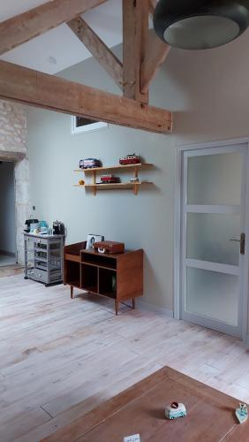 a living room with a wooden table and a door at Ancienne école de Colombier in Colombier