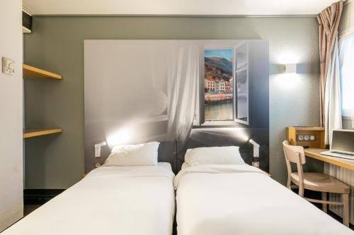 Tempat tidur dalam kamar di B&B HOTEL Grenoble Université