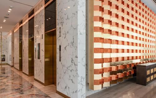 a lobby with a wall of wood and tile at Mövenpick Living West Hanoi in Hanoi