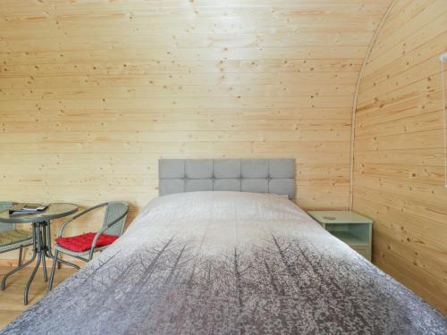 ein Schlafzimmer mit einem Bett in einer Holzwand in der Unterkunft Beulah in Axbridge