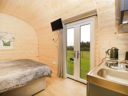 a bedroom with a bed and a sink and a kitchen at Suffolk in Axbridge