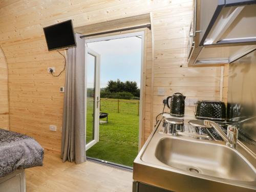een keuken in een tiny house met een wastafel en een raam bij Suffolk in Axbridge