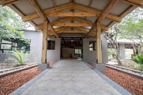 a pavilion with a wooden ceiling and a walkway at Little Africa Safari Lodge in Hoedspruit