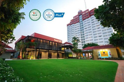 a large building with a green lawn in front of it at Hua Hin Grand Hotel and Plaza - SHA Extra Plus in Hua Hin