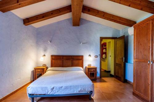 a bedroom with a bed and two wooden cabinets at Ermita de Santa Llúcia - Casa rural histórica in Tonya