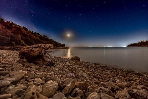 a starry night over a body of water at Apartments Anita in Pula
