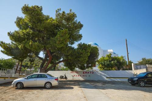 a car parked in a parking lot next to a tree at Erato Hotel in Agia Marina Aegina