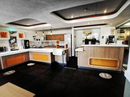 eine Küche mit weißen Arbeitsflächen und orangefarbenen Akzenten in der Unterkunft SUN1 BLOEMFONTEIN in Bloemfontein