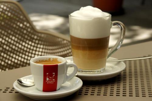 two cups of coffee on plates on a table at Solaris Apartman&Resort in Cserkeszőlő